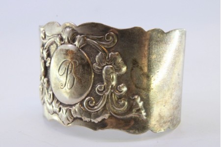 Argola de guardanapo em prata com relevos florais envolvendo cartela para monograma.